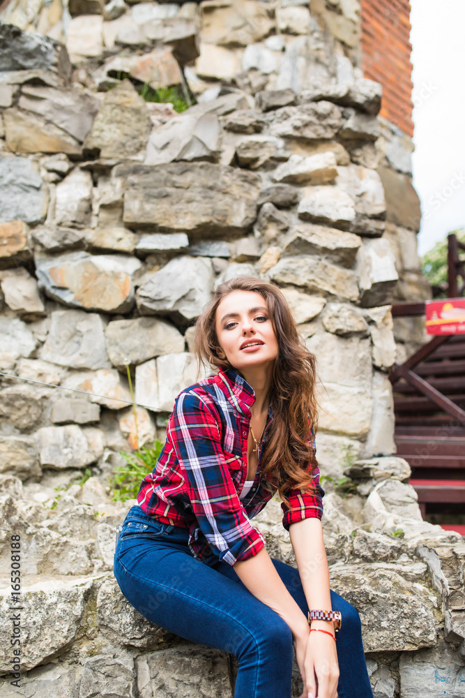 Pretty young slim woman posing against stone wall Pretty young slim woman posing against stone wall