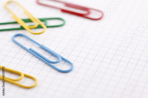 Colorful paper clips on graph paper with copy space