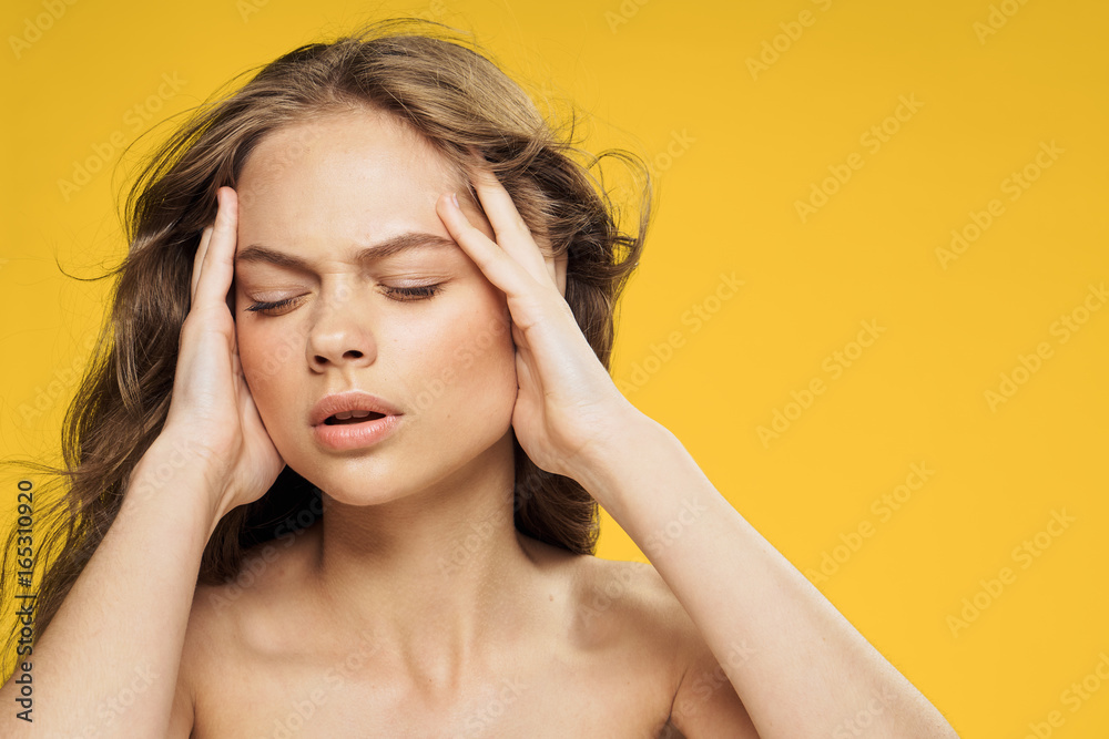 Fototapeta premium Beautiful young woman on a yellow background