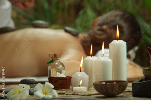 portrait of young beautiful woman in spa environment. focused on candles.