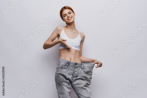 Young beautiful woman on a light background, diet, weight loss, progress, success © SHOTPRIME STUDIO