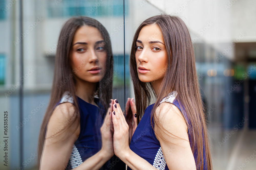 Stylish lady in blue dress posing near mirrored wall Stylish lady in blue dress posing near mirrored wall