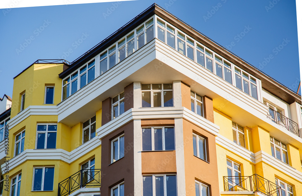 Details of new constructed colorful multi-story building. Modern residential construction. Residential fund. Building of he city. New yellow house