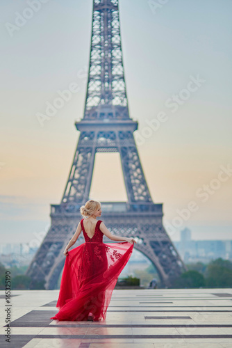 Woman in long red dress dancing near the Eiffel tower in Paris, France © Ekaterina Pokrovsky