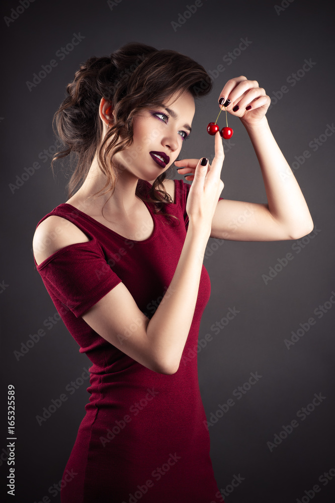 beautiful elegant girl in red dress with cherry in hands beautiful elegant girl in red dress with cherry in hands