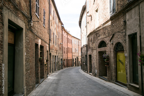 Curved street of an ancient medieval Italian village  with wooden doorways and windows. Traveling Italy  Tuscany and Umbria .