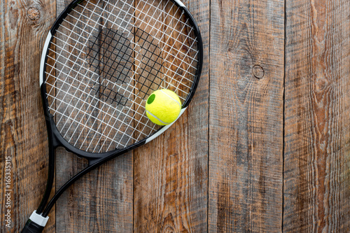 Sport background. Tennis ball and racket on wooden background top view copyspace © 9dreamstudio