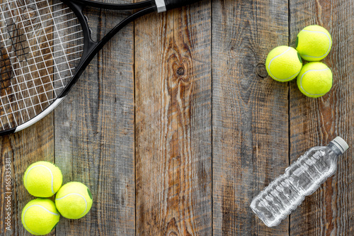 Sport background. Tennis balls and racket on wooden background top view copyspace © 9dreamstudio