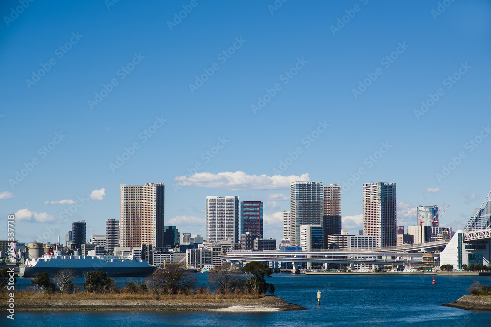 Skyline of Tokyo as seen from Odaiba at day. Clear blue sky over the bay. Skyline of Tokyo as seen from Odaiba at day. Clear blue sky over the bay.
