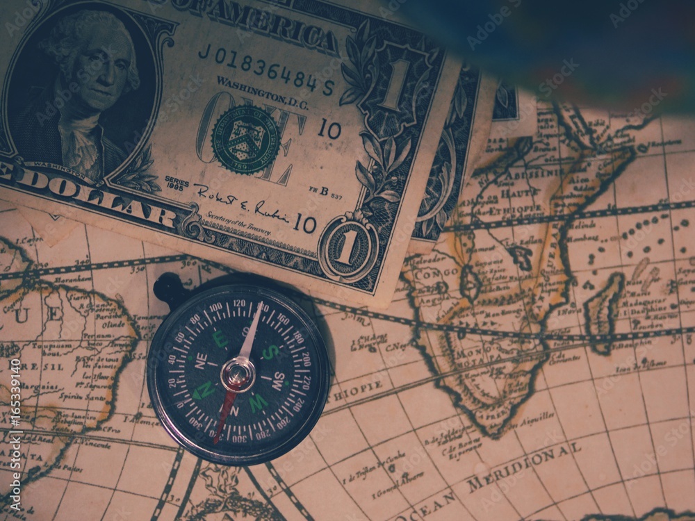Antique pirate world map and new modern compass concept travel around the world with one dollar money of United States of America, vintage vintage Antique pirate world map and new modern compass concept travel around the world with one dollar money of United States of America, vintage vintage
