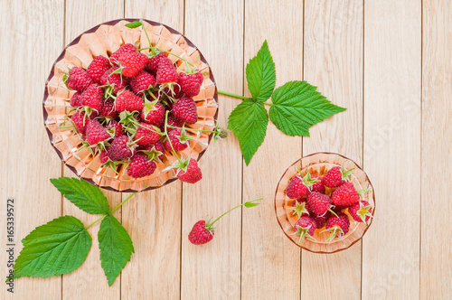 Fresh berries of raspberries on a plate on a wooden table