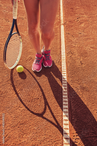 Female legs with tennis racket © Kirill Grekov