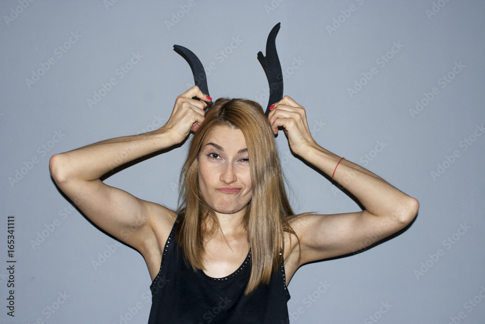 Drunk girl makes funny face with horns on head Stock Photo | Adobe Stock