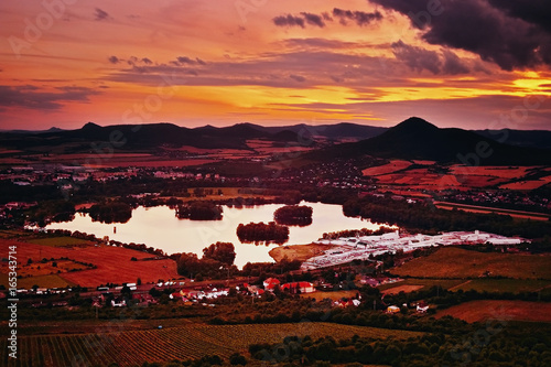 View to Zernosecke jezero lake and Lovos hill from Radobyl hill  in CHKO Ceske Stredohori tourist area after sunset  in czech summer landscape photo