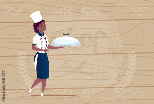 Female African American Chef Cook Holding Tray With Dish Smiling Cartoon In Restaurant Uniform Over Wooden Textured Background Flat Vector Illustration