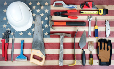 Labor Day holiday background with USA rustic wooden flag and many worker tools