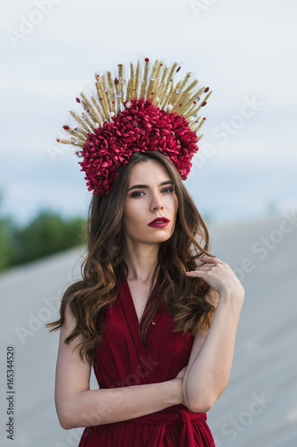 Beautiful girl in a red dress on the beach. Concept of femininity, harmony. photo