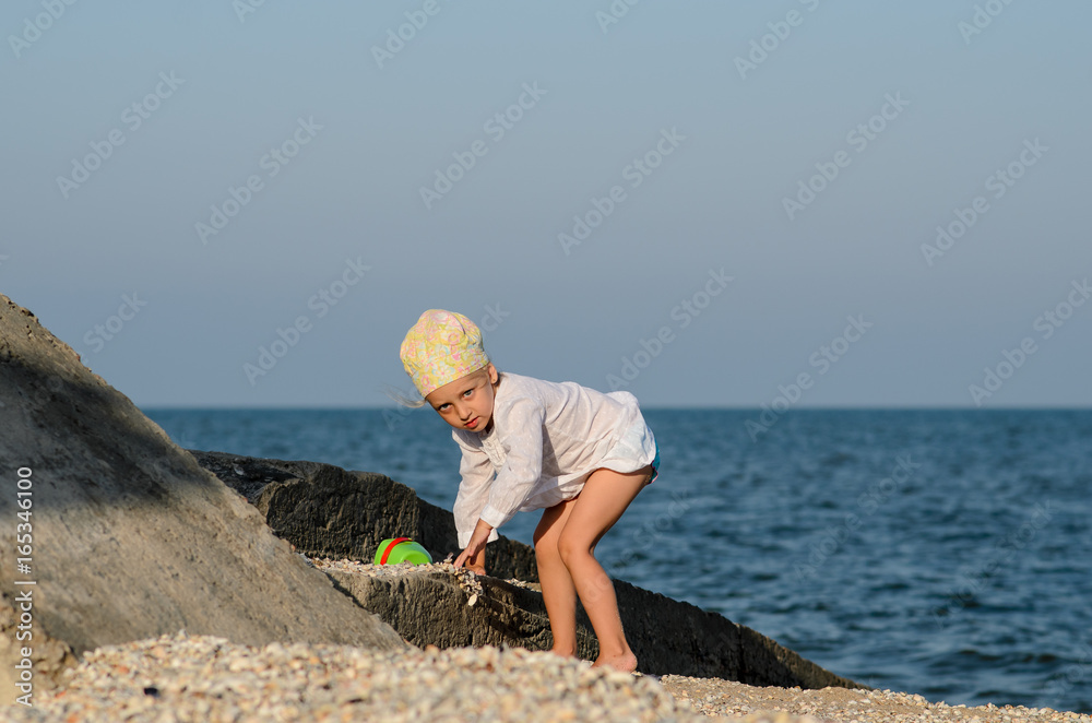 Girl playing on the beach with sand.
