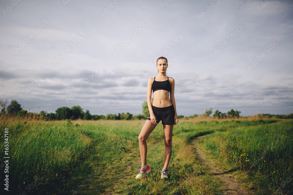 Fitness sport girl runner taking break after jogging outdoors Fitness sport girl runner taking break after jogging outdoors