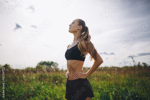 Fitness sport girl runner taking break after jogging outdoors