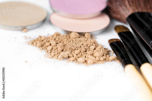  beige powder for face, eye shadow and makeup brush on white background