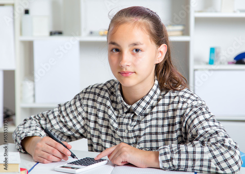 Teenage girl preparing for exams. Teenage girl doing homework for school.