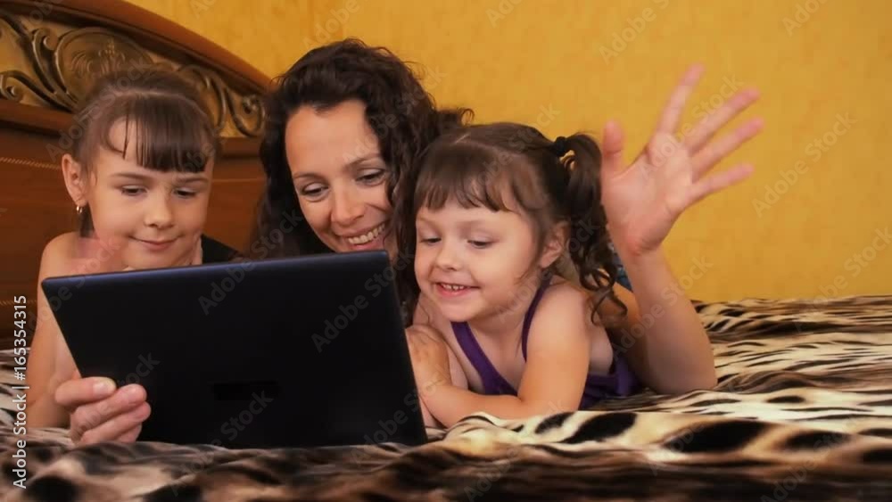 The family communicates on the tablet. Mom and daughter talk on skype. The family communicates on the tablet. Mom and daughter talk on skype.