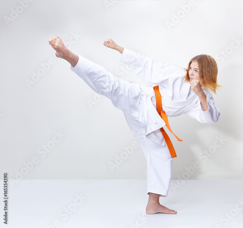 A circular kick is training by a girl in karategi