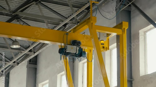 Overhead crane moves in large workshop