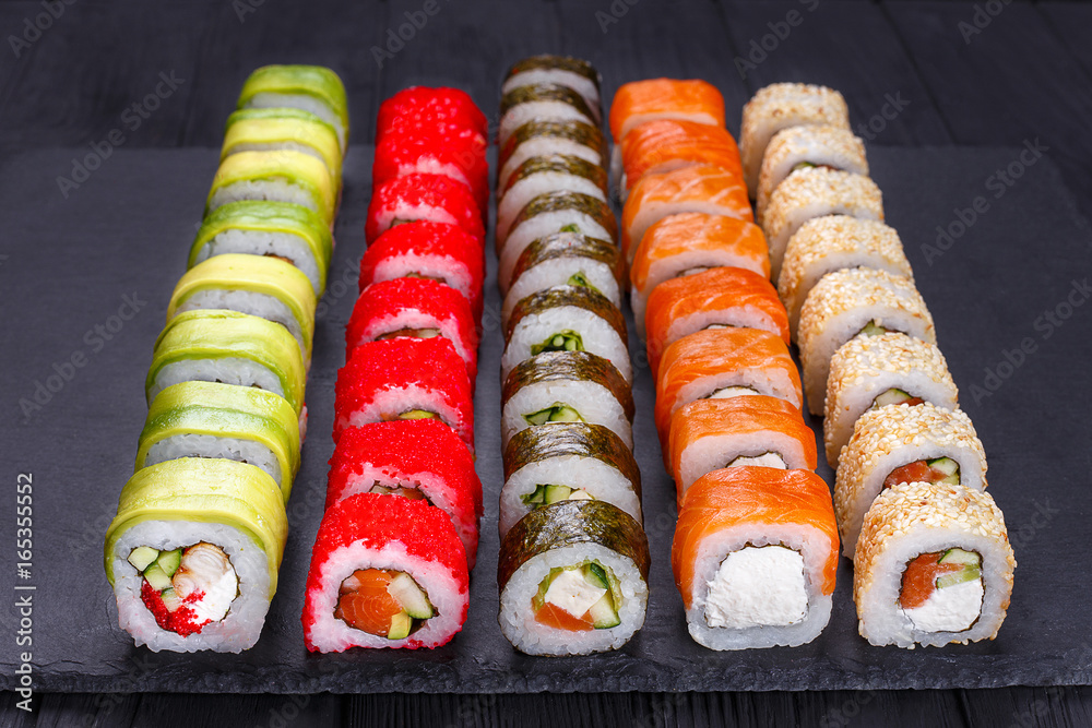 Japanese sushi set - various maki sushi roll on black stone slate. Japanese cuisine concept Japanese sushi set - various maki sushi roll on black stone slate. Japanese cuisine concept