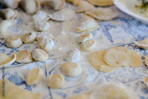 Closeup view of making traditional dumplings on kitchen table background