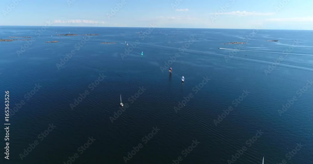 Yachts on baltic sea, Cinema 4k aerial tilt up view above the baltic sea and towards a group of colorful sailboats, out on the turquoise sea, on hango regatta day, in the finnish archipelago Yachts on baltic sea, Cinema 4k aerial tilt up view above the baltic sea and towards a group of colorful sailboats, out on the turquoise sea, on hango regatta day, in the finnish archipelago