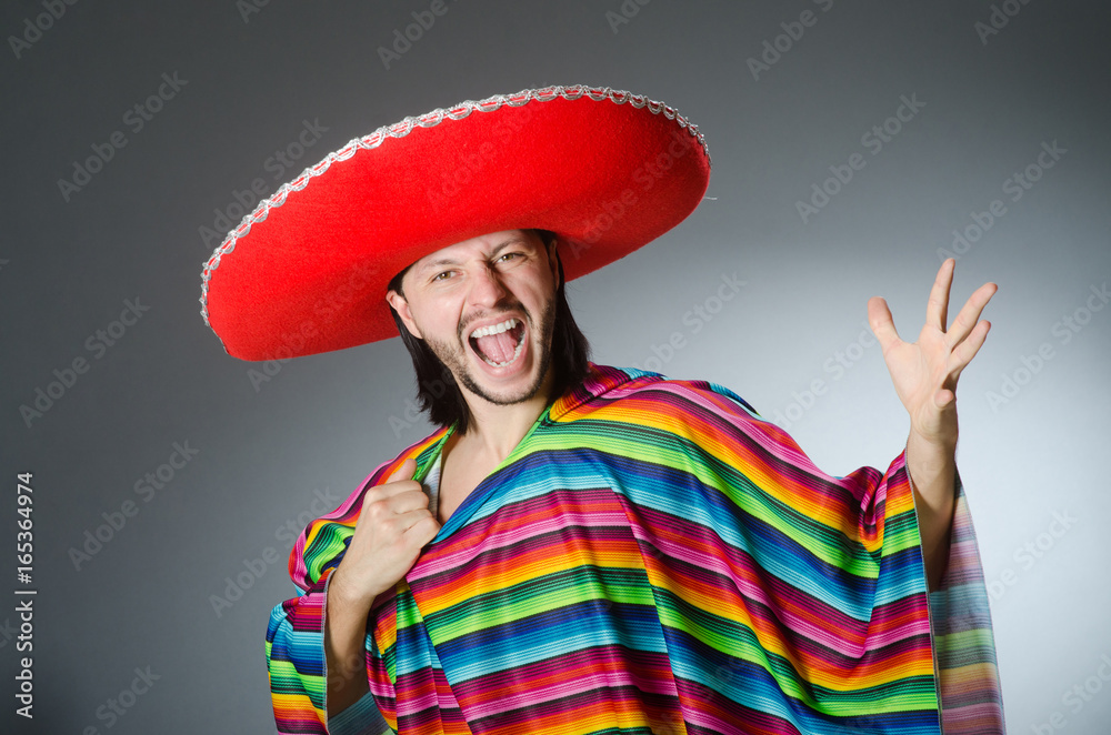 Man in a vivid mexican poncho gray background isolated Man in a vivid mexican poncho gray background isolated