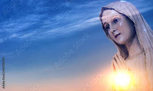 Tela Statue of the Virgin Mary against sunrise