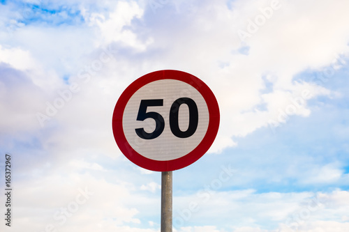 Road sign speed limit to 50, traffic sign in blue sky background