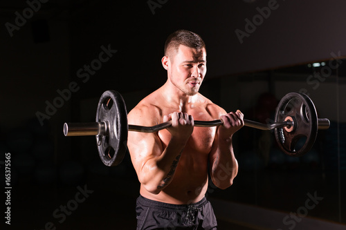 young man doing heavy weight exercise for biceps.