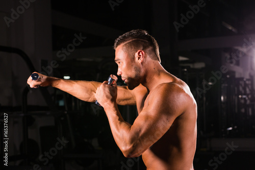 Boxing concept. Boxer man during boxing exercise making direct hit with dumbbells photo