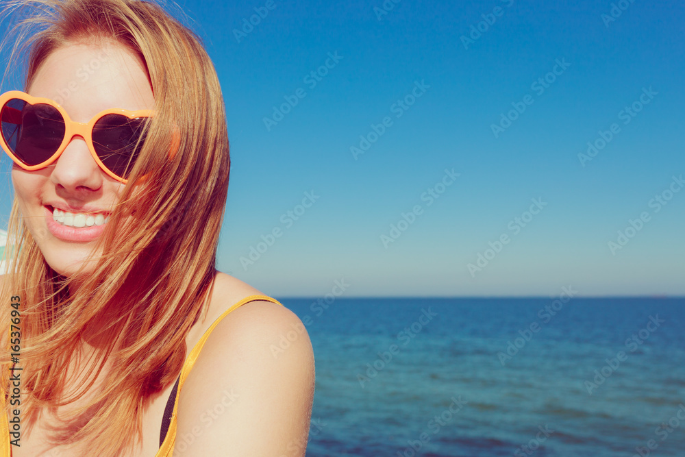 Girl in red sunglasses relaxing on sea coast.
