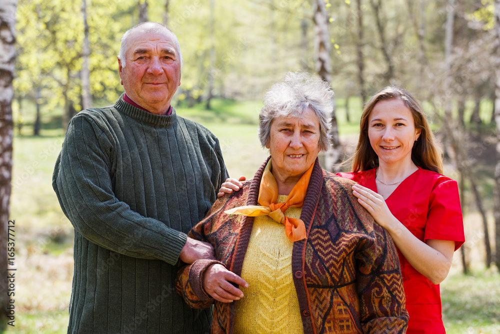 Elderly couple and young caregiver