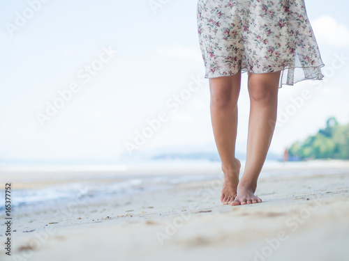 Beach travel - woman walking on sand beach. Closeup detail of female feet .Step up concept. © Siam