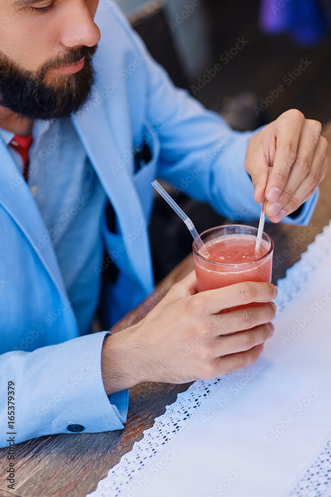 Bearded male drinks, fresh juice at a cafe. Bearded male drinks, fresh juice at a cafe.