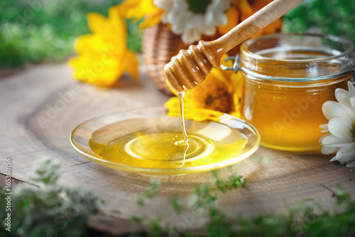 Fresh flower honey on a wooden table. Selective focus.