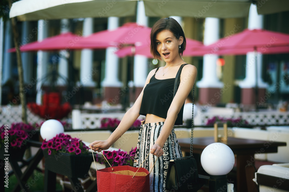 young beautiful girl posing on the street . Model wearing stylish clothes . Urban lifestyle. The concept of fashion and shopping