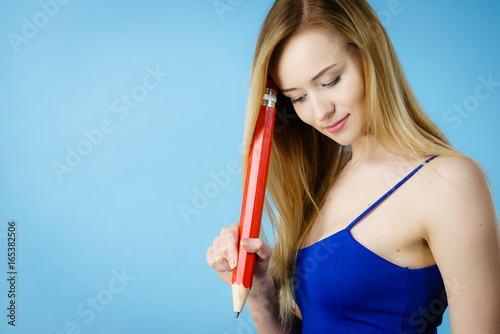 Woman confused thinking  big pencil in hand