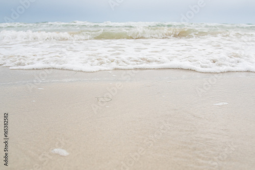 Soft wave of blue ocean on sandy beach. Background.