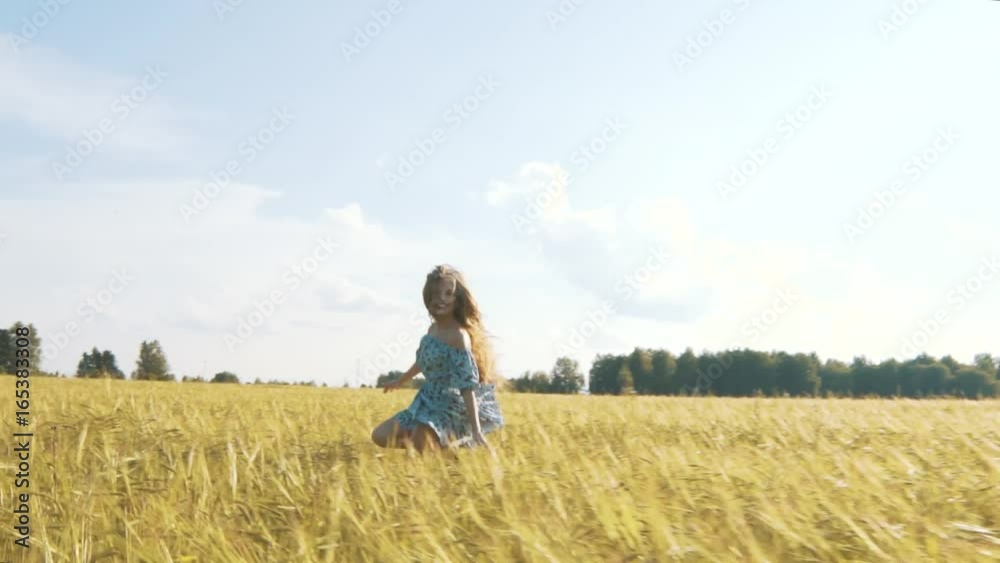 Beautiful girl running on sunlit wheat field. Slow motion 120 fps. Sun lens flare. Freedom concept. Happy woman having fun outdoors in a wheat field on sunset or sunrise. Slow motion. Harvest. Beautiful girl running on sunlit wheat field. Slow motion 120 fps. Sun lens flare. Freedom concept. Happy woman having fun outdoors in a wheat field on sunset or sunrise. Slow motion. Harvest.