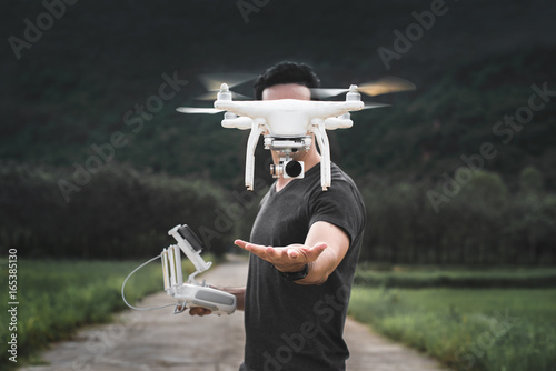 Drone is taking off from man hands. Young man releasing aerial copter to fly with small digital camera. Modern technology in our life. photo