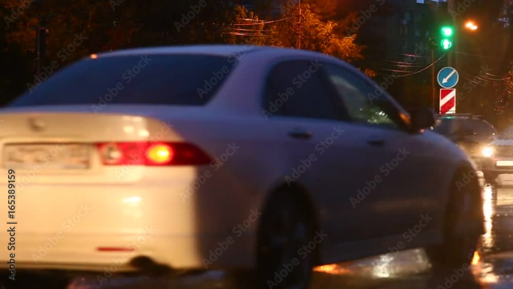 Rainy night road with traffic lights and cars moving Rainy night road with traffic lights and cars moving