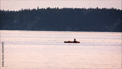 Paddling along in a kayak near a forest
