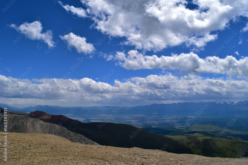 View of blue sky with white clouds and ridge of Altai mountains